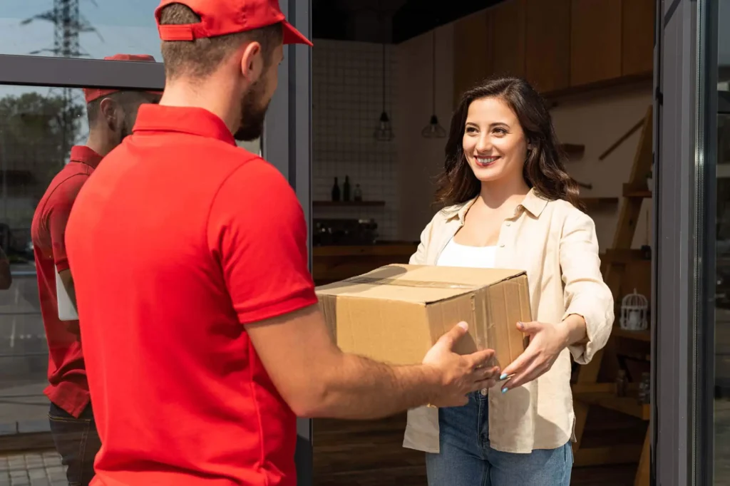 Mover handing a cardboard box to a customer during a household move